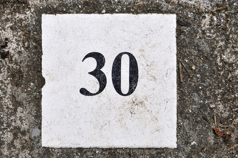 white tile with the number 30 on a texture background concrete white tile with the number 30 on a texture background concrete