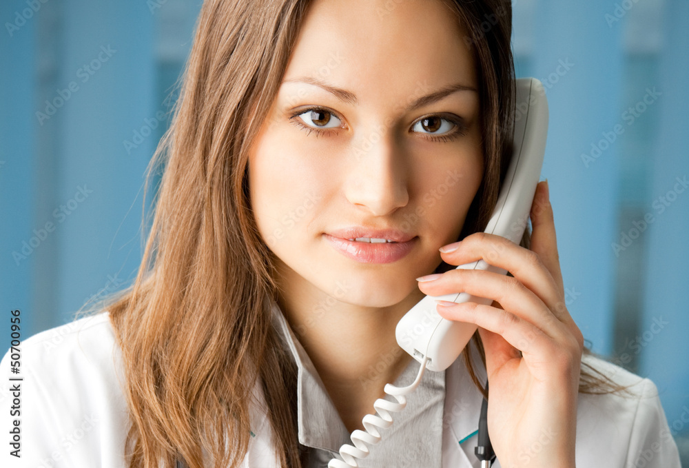Young doctor on phone, at office Young doctor on phone, at office