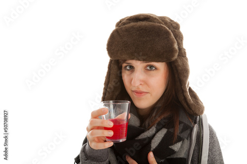 Das junge Mädchen trinkt ein Glas Medizin