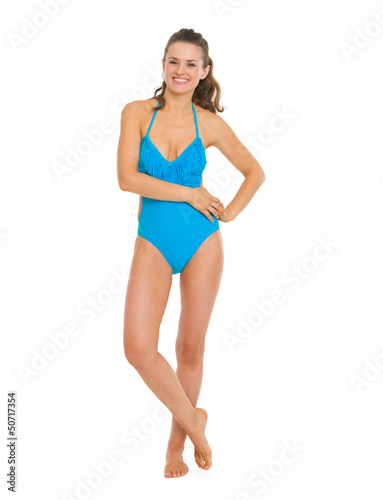 Full length portrait of smiling young woman in swimsuit