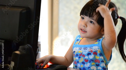 three action shot cute asian baby use computer