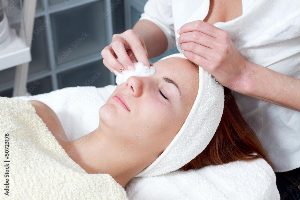 young woman having facial beauty treatment at beauty salon