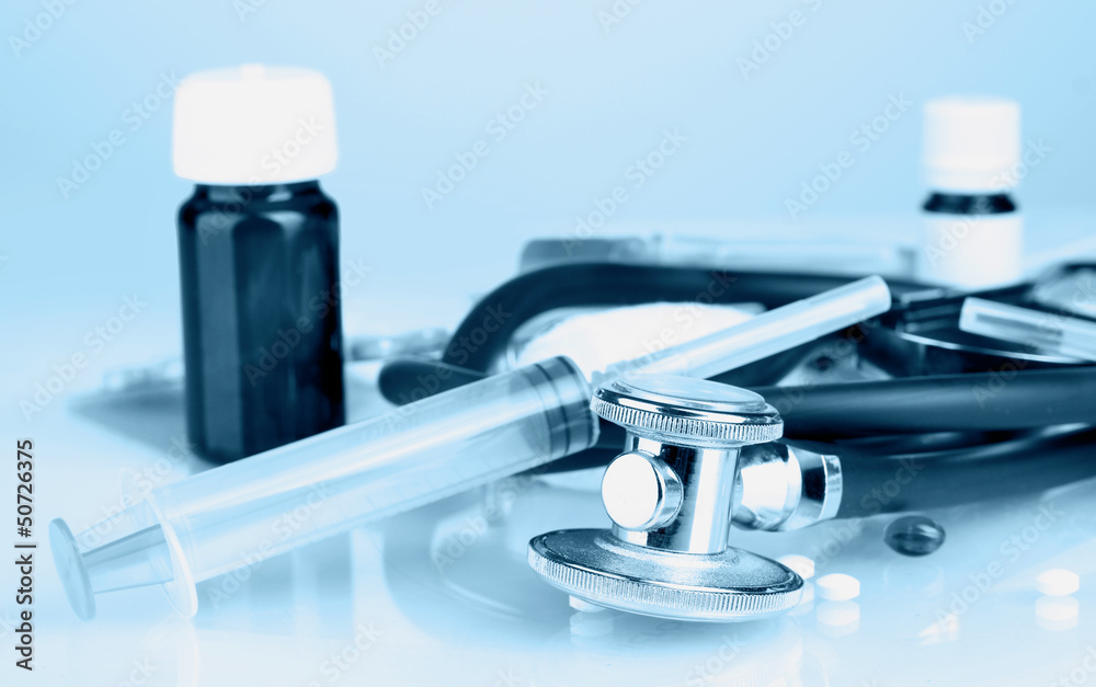 Fototapeta premium Medicines and stethoscope in blue light