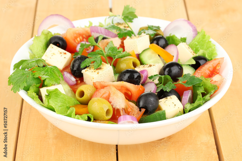 Fresh salad in plate on wooden table Fresh salad in plate on wooden table