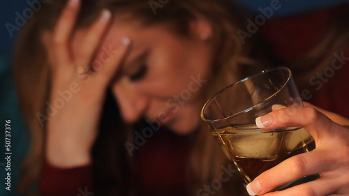 Woman drinking alcohol. Glass in sharp focus.