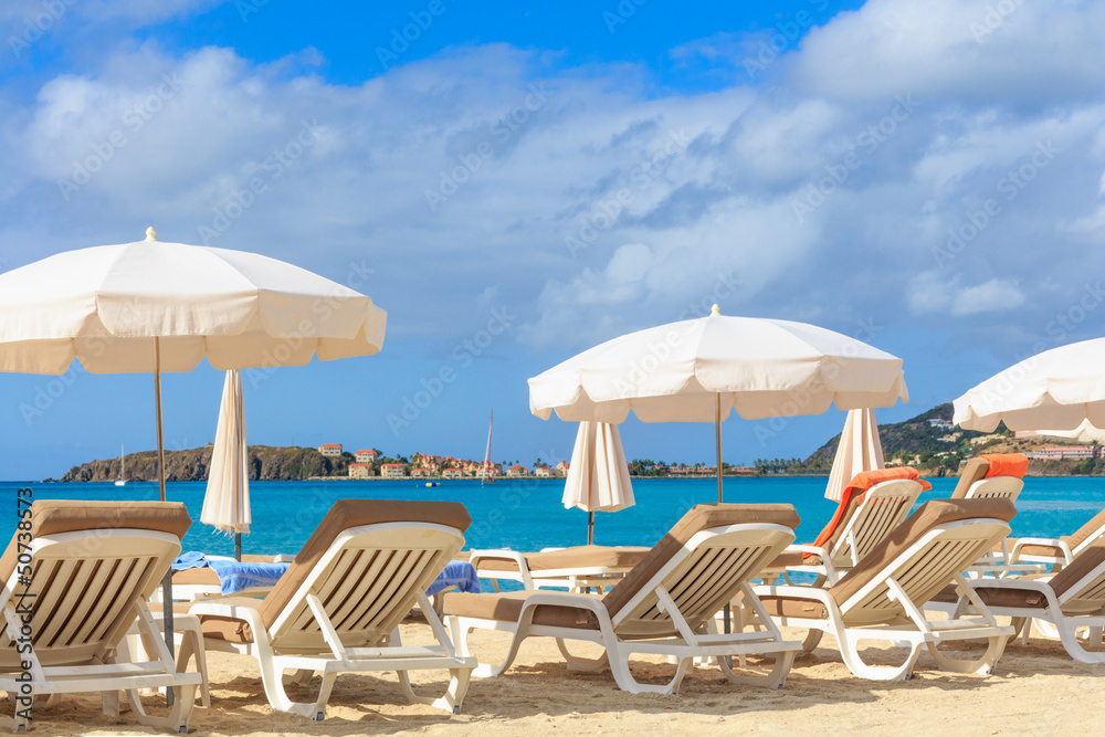Beach chairs and parasols on a beach in a tropical paradise