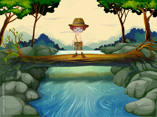 A boy standing above the trunk at the river