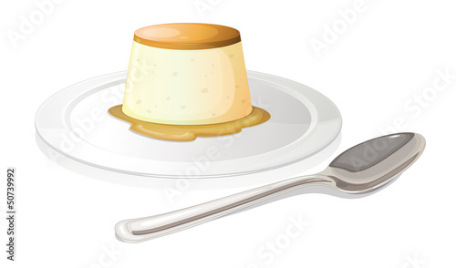 A spoon beside a plate with a leche flan