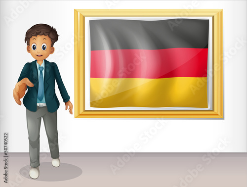 A boy beside the framed flag of Germany