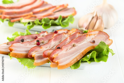 Bacon with pepper on white wooden
