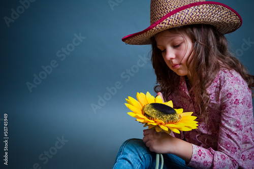 Little cowgirl with a sunflower