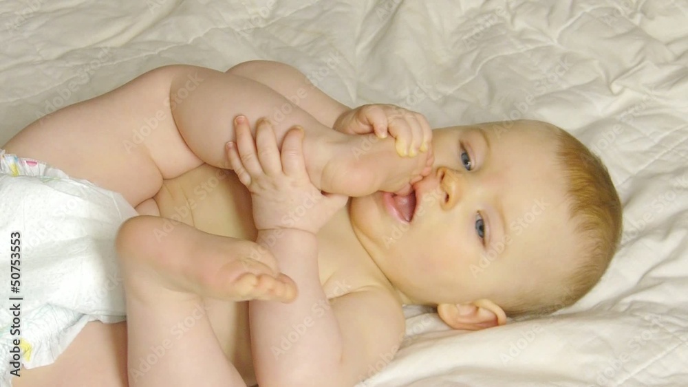 HD1080p Baby laying on a blanket puts her foot in her mouth HD1080p Baby laying on a blanket puts her foot in her mouth