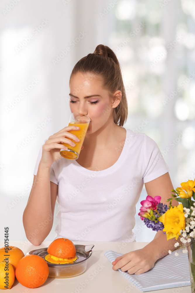 Young beautiful woman drinking a glass of orange juice Young beautiful woman drinking a glass of orange juice