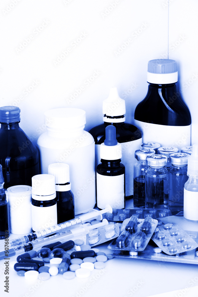 Medical bottles and pills in blue light Medical bottles and pills in blue light
