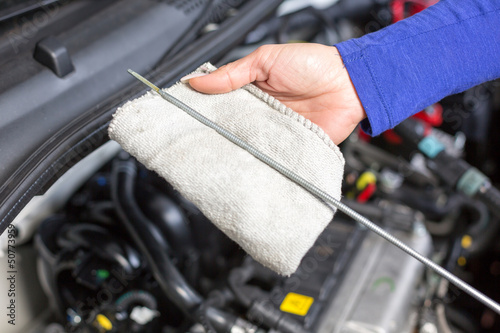 Car mechanic taking a look at the oil level