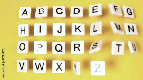 Plastic letters bouncing and showing alphabet on yellow surface