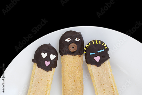 Three ladyfingers cakes decorated as a family. photo