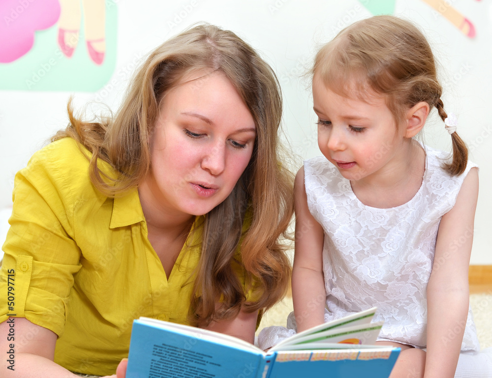 Young woman and little girl read a book