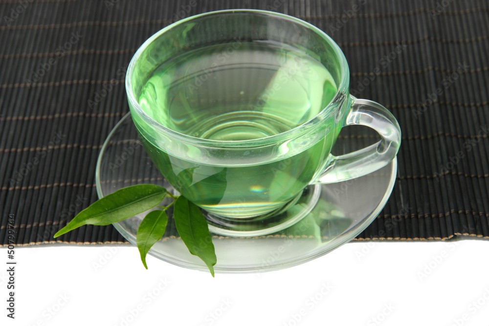 Transparent cup of green tea on bamboo mat, isolated on white Transparent cup of green tea on bamboo mat, isolated on white