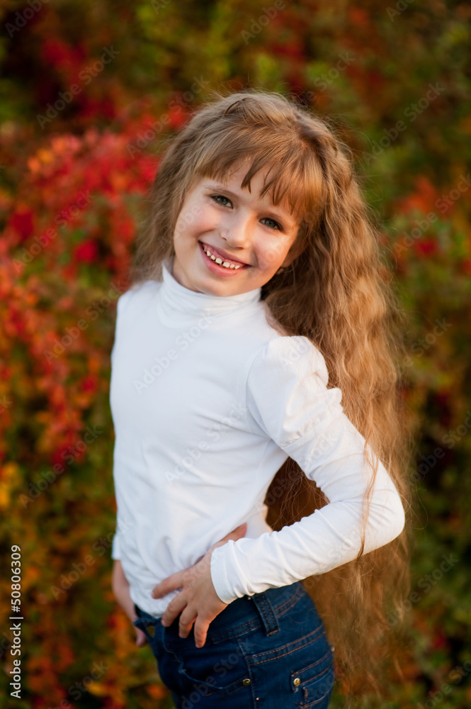 Portrait of a smiling girl in a white turtleneck and jeans in th Portrait of a smiling girl in a white turtleneck and jeans in th
