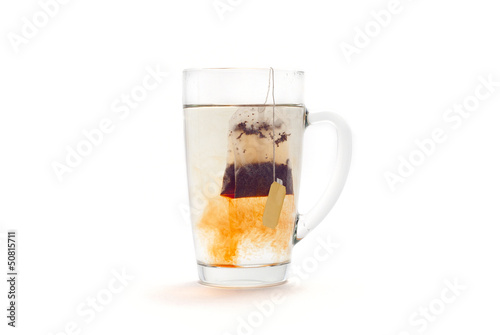 Tea in a glass cup on a white background. Tea bag