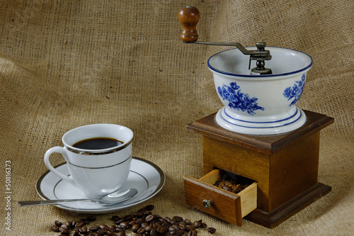 Cup of Coffee with an Antique Coffee Mill