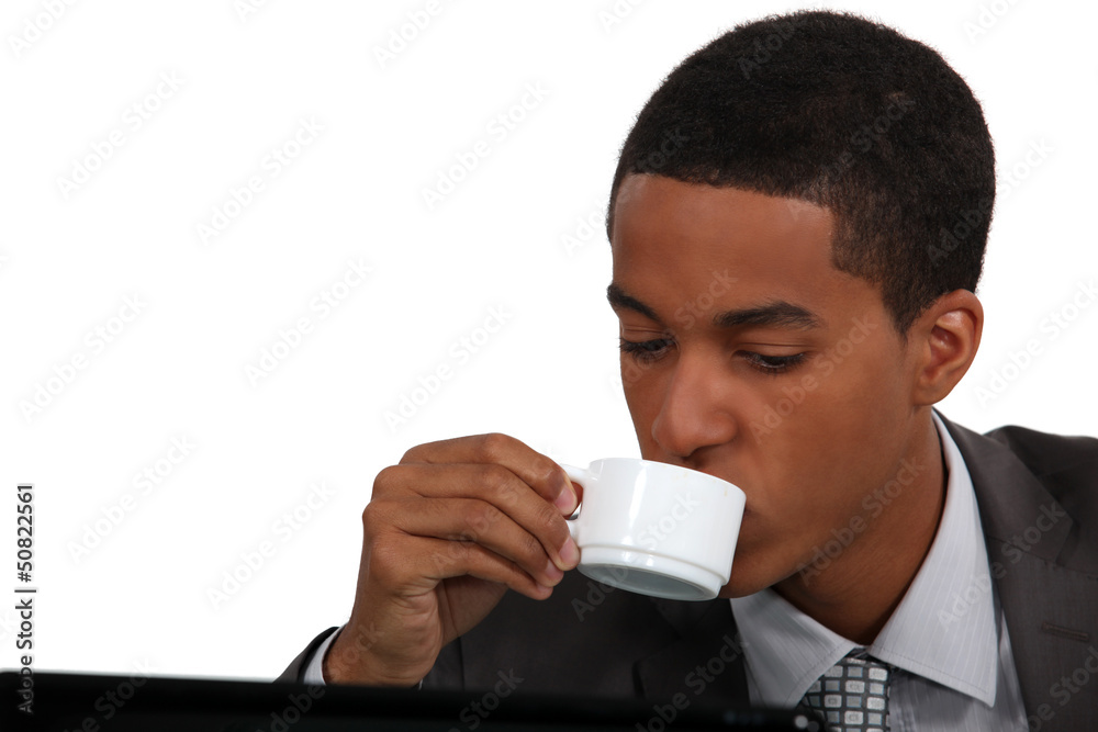 Businessman drinking coffee by laptop Businessman drinking coffee by laptop
