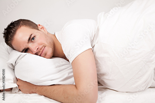 beautiful young man lying in bed