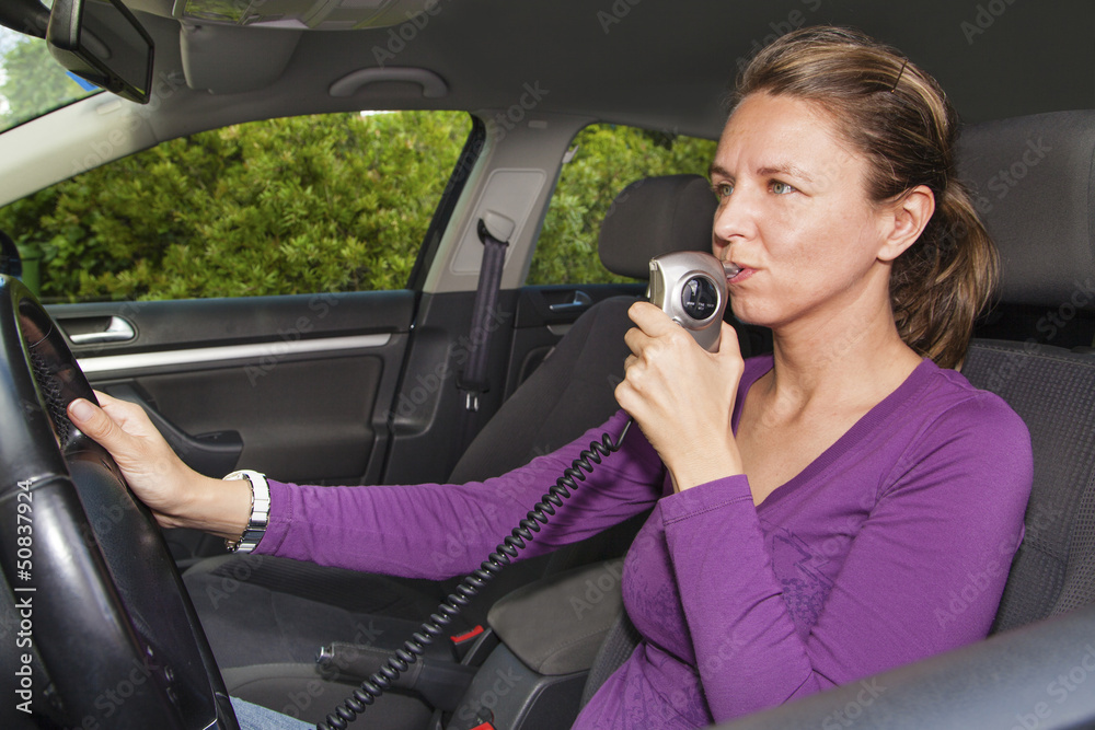 Woman blowing into breathalyzer Woman blowing into breathalyzer