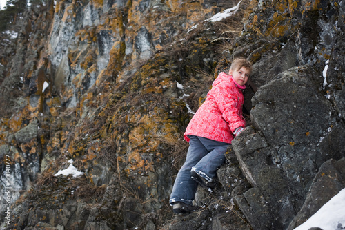 young Girl climbs the rocks © tuzyra