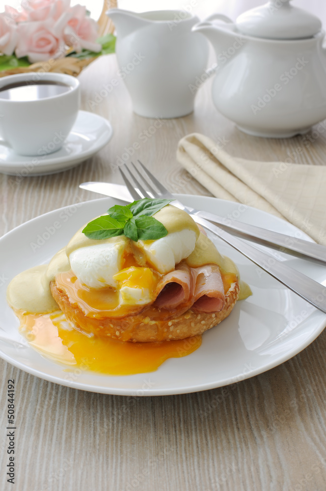 Boiled eggs (poached) with ham on a bun with sauce Boiled eggs (poached) with ham on a bun with sauce