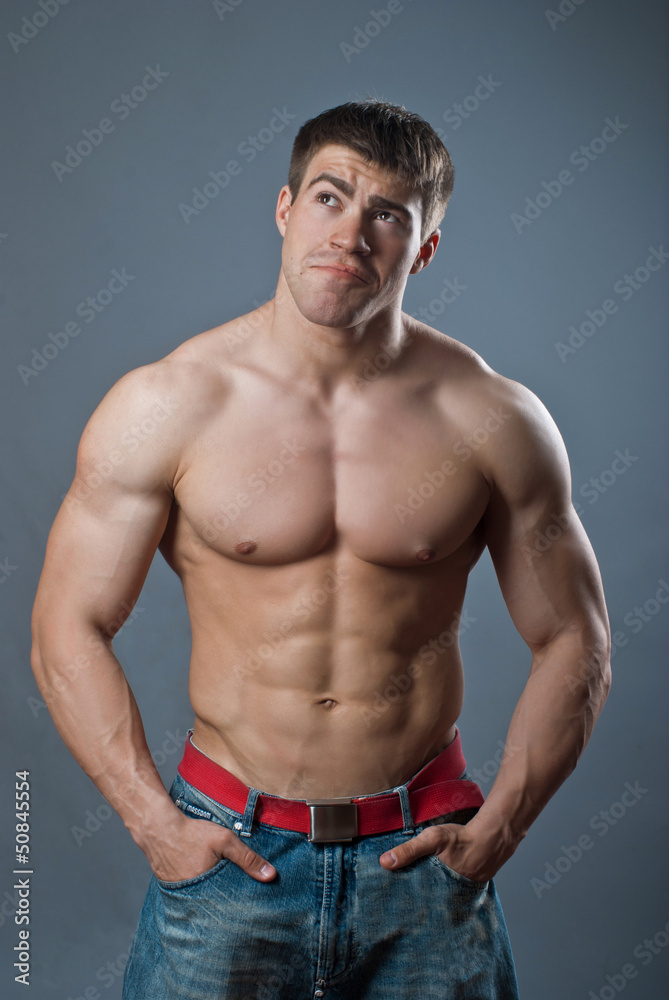 Young attractive muscular man on a black background