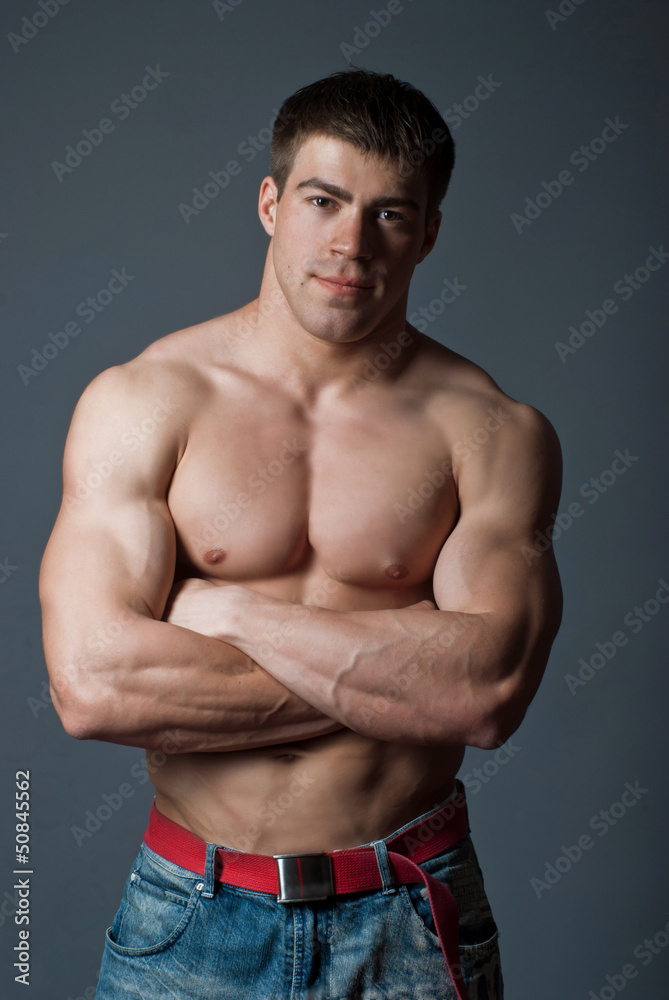 Young attractive muscular man on a black background