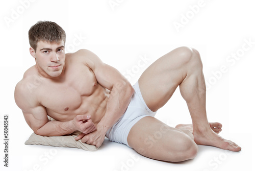 An attractive young man, lying on a cushion