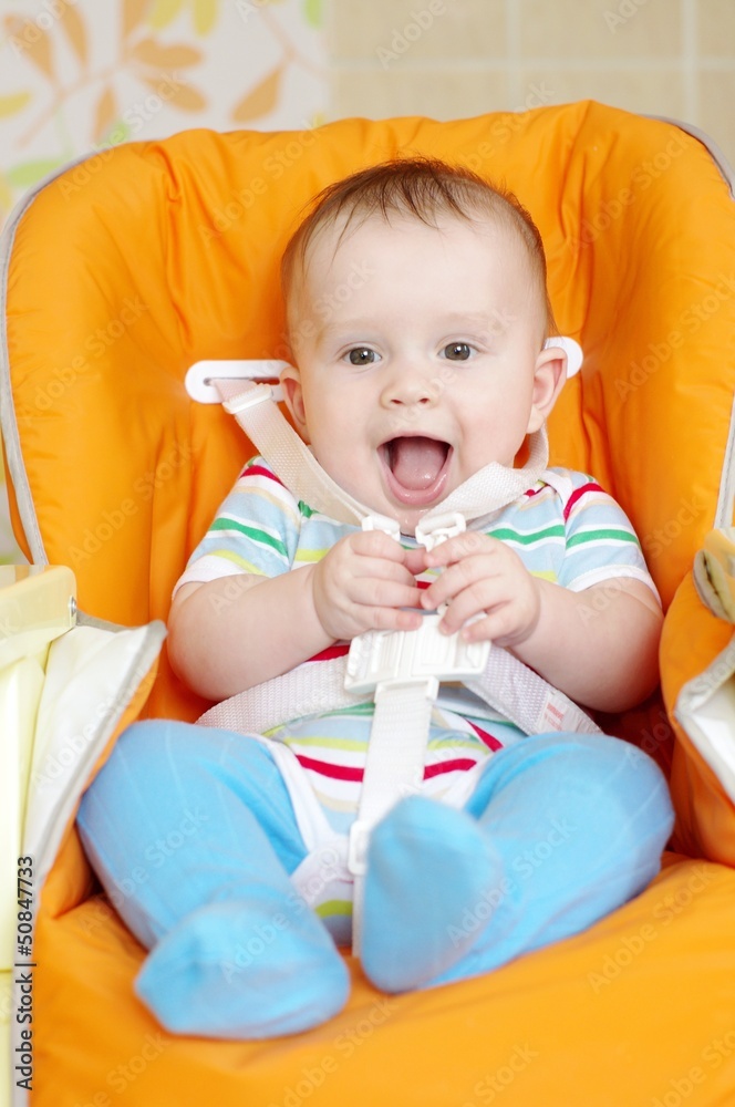 Laughing baby sitting on babies chair age of 6 month Laughing baby sitting on babies chair age of 6 month