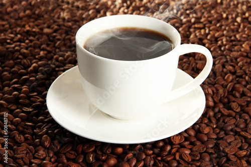 Cup of coffee on coffee beans background