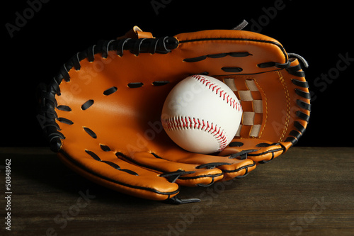 Baseball glove and ball on dark background