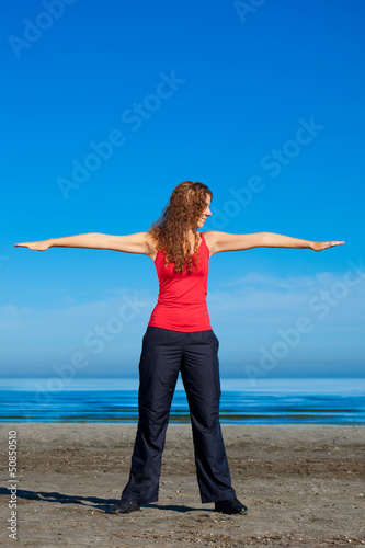 girl doing morning exercises at the beach