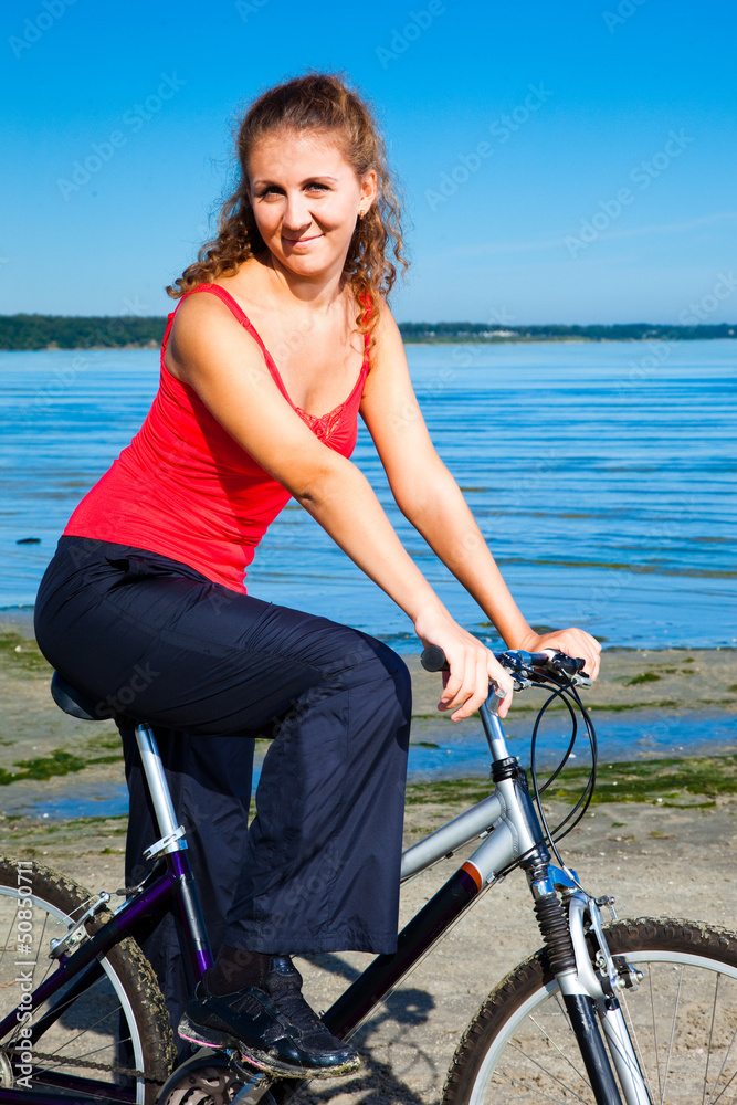 Fototapeta premium beautiful woman with bicycle at the sea