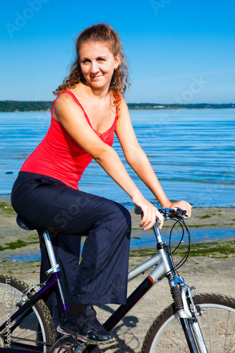 beautiful woman with bicycle at the sea