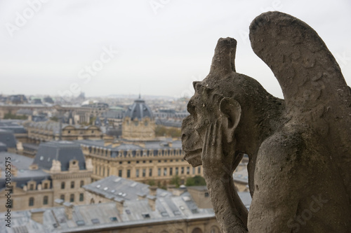 Stone gargoyle overlooking Paris from the Notre Dame