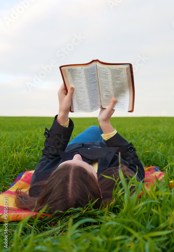 Obraz na płótnie Teen girl reading the Bible outdoors w salonie