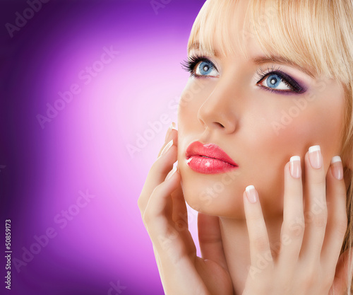 Beautiful blonde woman with manicure and purple makeup