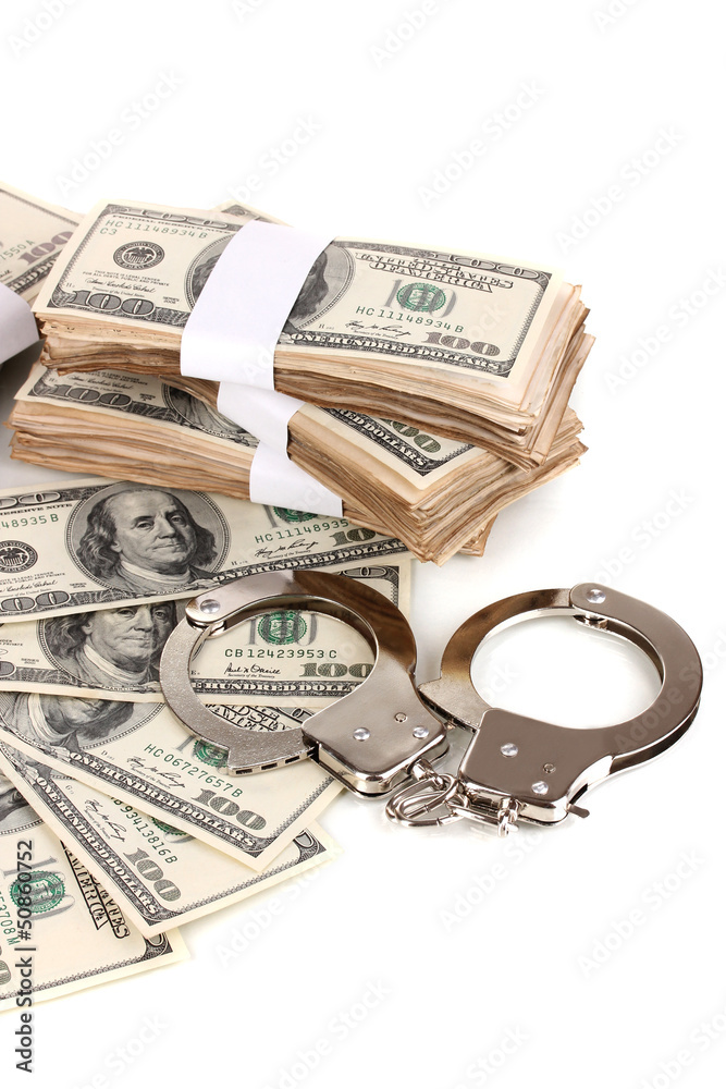 Handcuffs and packs of dollars on white background close-up Handcuffs and packs of dollars on white background close-up