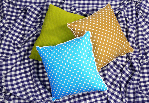 Three various pillows on plaid