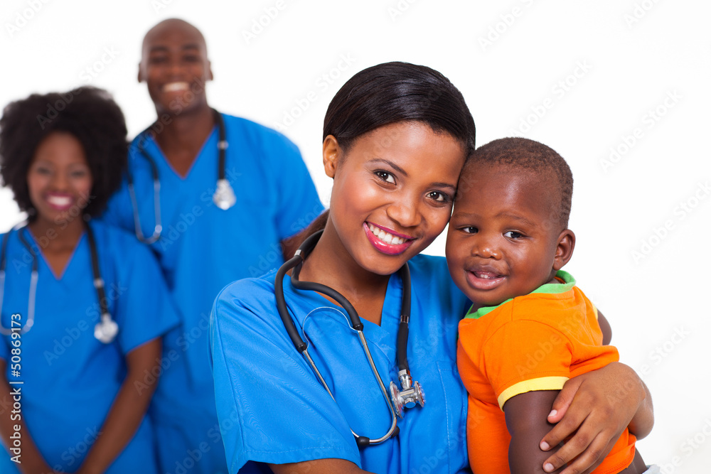black pediatrician and baby boy with co-workers on background black pediatrician and baby boy with co-workers on background