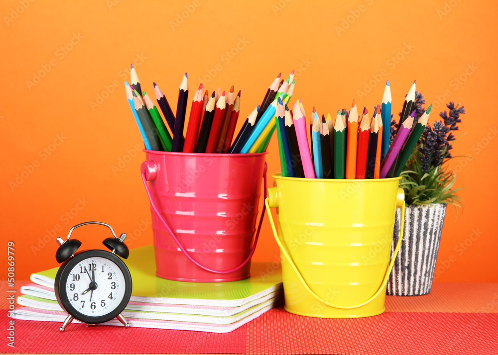 Colorful pencils in two pails with copybooks Colorful pencils in two pails with copybooks