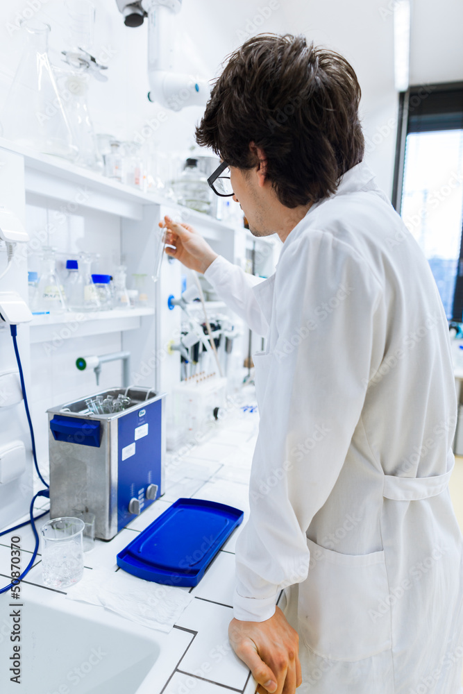 Young male researcher carrying out scientific research in a lab Young male researcher carrying out scientific research in a lab
