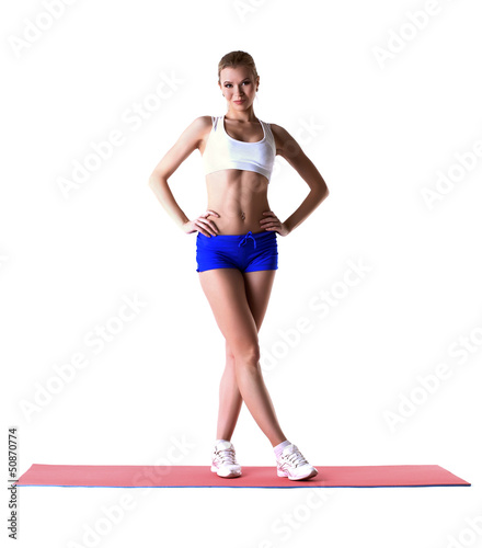 Beautiful slim woman posing on gymnastic mat