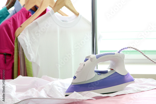 Electric iron and shirt, on cloth background